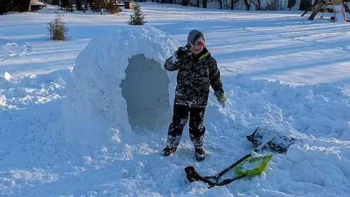 Wyatt standing next to our epic igloo